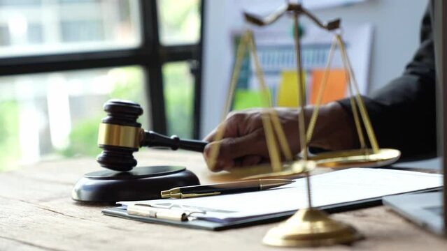 Lawyer or judge holding Hammer prepares to judge the case with justice, and litigation, scales of justice, law hammer, Legal consulting services, Concept of litigation, and legal services.
