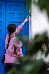 girl ringing the doorbell blue door