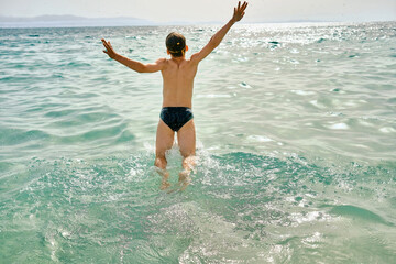 Happy boy in swimming goggles swim in the sea looking at view enjoying summer vacation. Togetherness Friendly concept