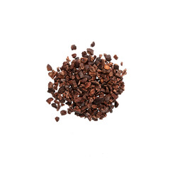 Pile of Cocoa nibs on white, top view. Crunchy pieces of peeled, crushed and lightly roasted cocoa beans with a pleasant chocolate bitterness. Sugar-free Dessert topping. Natural antidepressant
