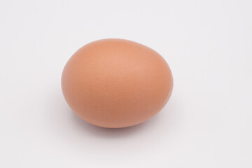 One chicken egg against a white background