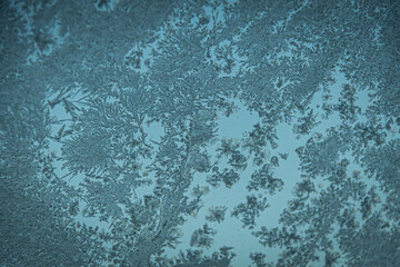 Frost ice crystals on the surface of glass in blue tones.
