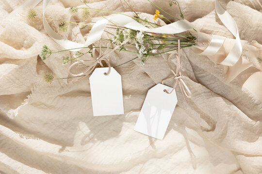 Tag cards mockup with wild flowers on beige background 