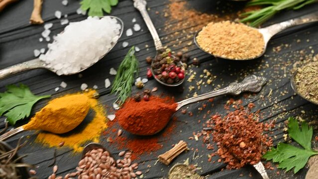 Colorful herbs and spices for cooking. Indian spices. On a black background. Top view