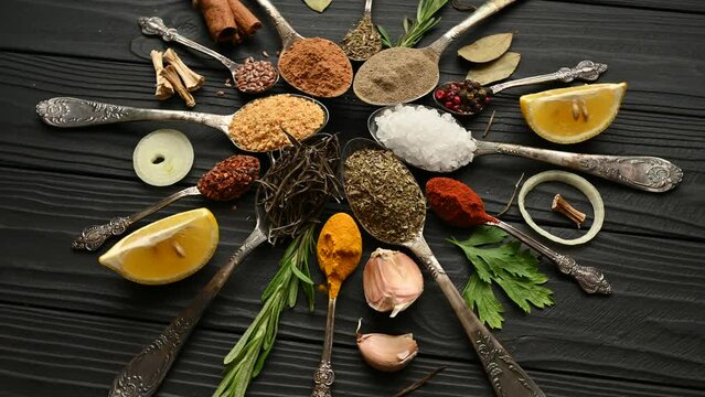 Colorful herbs and spices for cooking. Indian spices. On a black background. Top view