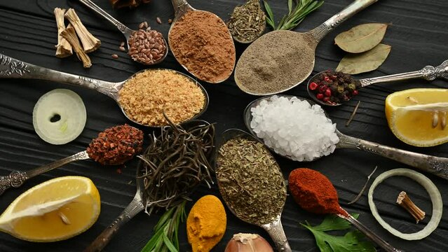 Colorful herbs and spices for cooking. Indian spices. On a black background. Top view