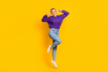 Fototapeta na wymiar Full size photo of excited carefree girl jumping show v-sign have good mood isolated on yellow color background