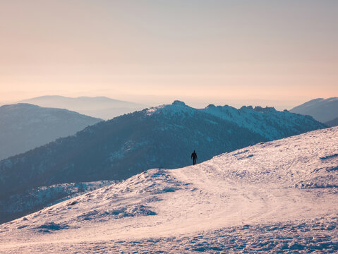 Unrecognizable traveler walking on snowy mountain
