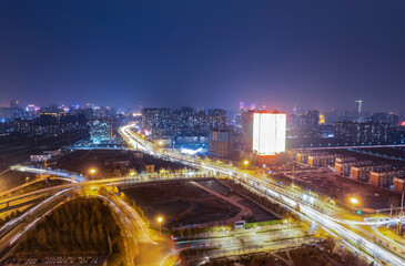 Fototapeta na wymiar Aerial shot of car track with night view of city overpass