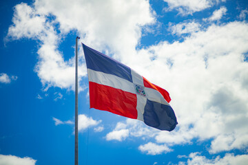 dominican flag waving in blue sky for independence day