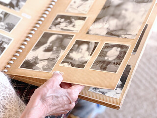 白黒写真のアルバムを見る高齢女性の手元