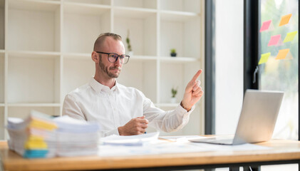 Young unhappy man office worker feeling bored at work, looking at laptop with demotivated face...