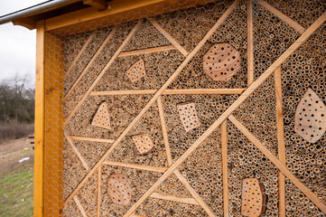 Close-up of a bee hotel sustainable environmental protection, yellow wood frame