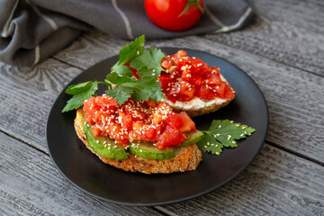 Bruschetta with cottage cheese, avocado, tomatoes, greens, white sesame seeds. Healthy food, rich in healthy fats, fiber, vitamins, antioxidants. Vegetarian food.