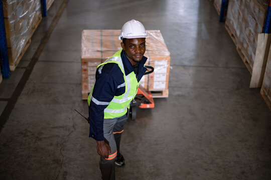Management pulling carts at warehouse with white hardhat and working in Logistics and distribution Center. Warehouse and logistic and business international export