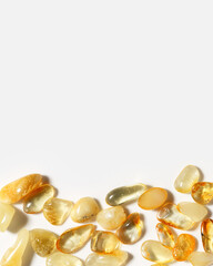 Natural gemstone amber texture background, stones yellow ivory white colors. Natural mineral light colored for jewelry. Top view Amber texture. Aesthetic sunstones wallpaper, uncut stones.