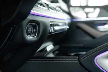 Fototapeta na wymiar engine start stop button in a prestigious car with ambient lighting