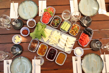 a table with a variety of food on it and plates and wine glasses on it, all on a wooden table