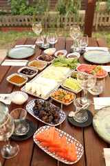 a table with plates and bowls of food on it and wine glasses on the table