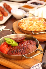 a table with a variety of food on it and a plate of pizza on the side of the table