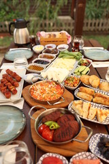 a table full of food and people reaching for food on it with their hands and plates on the table