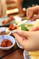 a person holding a fork with food on it in their hand and a plate with other food on it on the table
