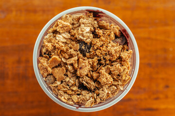  overhead photoof a creamy acai bowl with granola and banana on wooden background