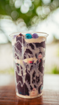 vertical photo of a creamy acai bowl with condensed milk, milk powder and colorful chocolate chips