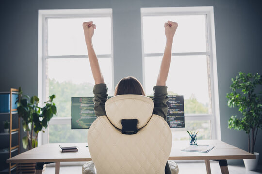 Photo of positive lucky lady hacker rising fists successful task fulfilment modern device indoors workplace workstation