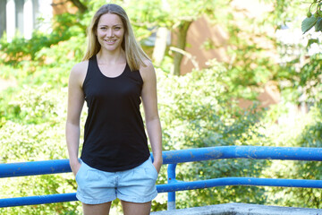 Young blonde woman wears a black tank top with copy space or text space for print or design