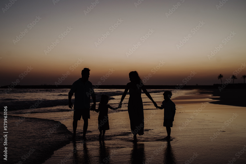 Wall mural Happy family with little kids enjoying time at sea in exotic country.