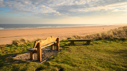 Bench overlooking Druridge Bay, located on the North Sea in Northumberland's AONB in England, it is...