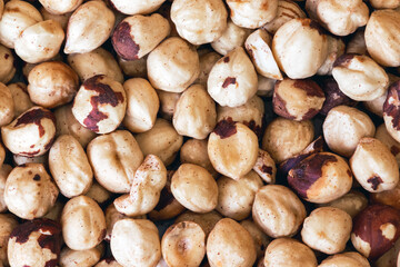 Peeled hazelnuts. Poorly peeled hazelnuts. Background of peeled hazelnuts.