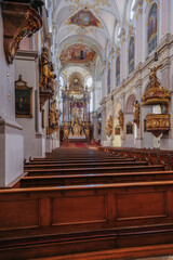 Fototapeta premium Magnificent opulent splendid Bavarian baroque church cathedral basilica interiors with stucco, murals, altar, Pilars, ceiling paintings, gold, wood domes nave