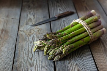 Green asparagus on wooden background. Raw food concept. The vegetable is rich in fiber, natural prebiotic.