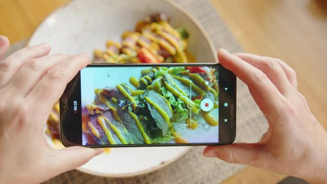Female hands shooting food by smartphone 