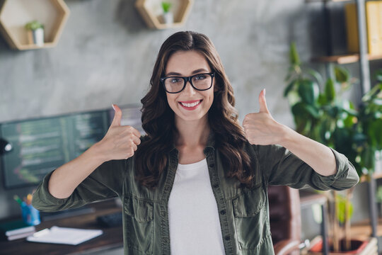 Photo of positive confident lady ceo wear eyeglasses showing two thumbs up indoors workplace workstation