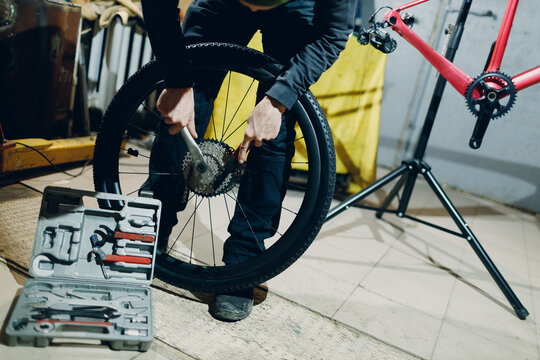 Mechanic repairman assembling set tools gear sprocket transmission custom bicycle in workshop