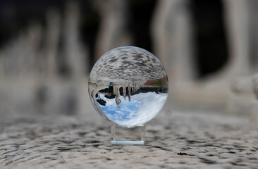 Stadio dei Marmi in Rome, row of statues of athletes reflected in a crystal ball, outline out of focus.