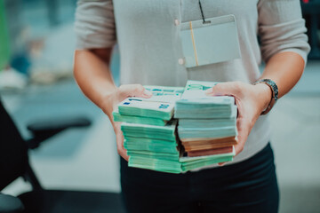 Bank employees using money counting machine while sorting and counting paper banknotes inside bank vault. Large amounts of money in the bank
