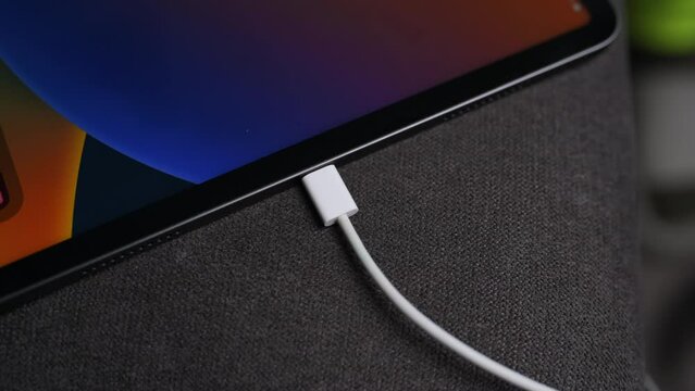 Inserting a TypeC  connector into the  port tablet close up. TypeC  connector system or connection interface in hand. Connecting TypeC  cable into a charger plugged. High quality 4k footage