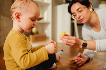 Mother and son playing with clay at home and creating art