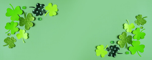 Happy St. Patrick's Day greeting banner mock up. Paper clover leaves on colored background
