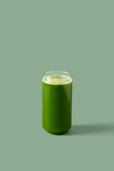 Celery juice in a glass on a green background