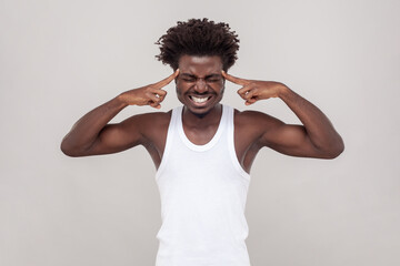 Unhealtty sick man with Afro hairstyle touches temples has unbearable headache suffers from migraine
