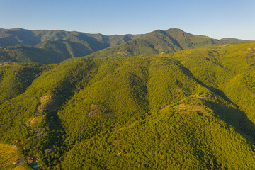 Drone photography of forested mountain side, farms and farmlands