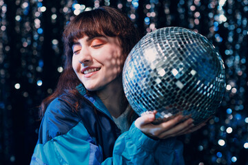Young sporty woman 80 and 90's style. 90s fashion positive girl at night club disco party with disco ball