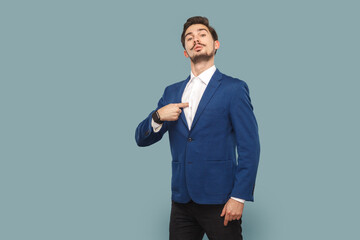 Self confident proud man with mustache standing pointing at himself, looking at camera with pride.