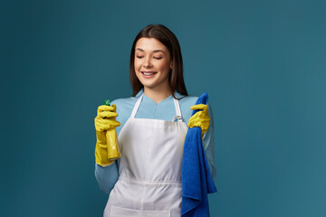 woman in cleaner apron wieaning rag and detergent sprayer