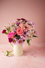 Beautiful fresh spring flowers. Pink bouquet of flowers in vase, on pink background.
